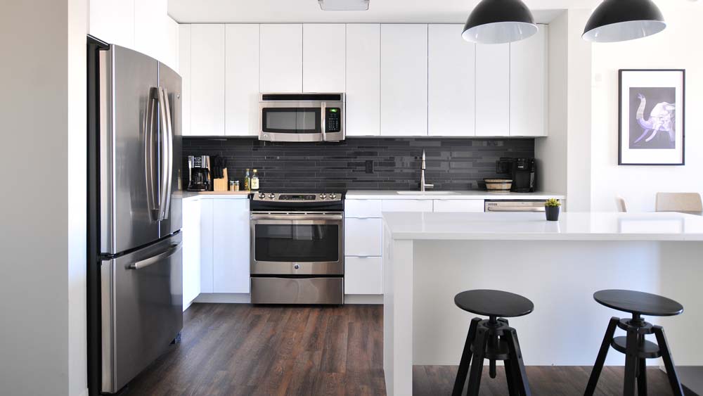 A kitchen with stainless steel appliances: a fridge, an oven, a microwave and a dishwasher.
